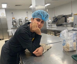 photograph of a man leaning on a counter